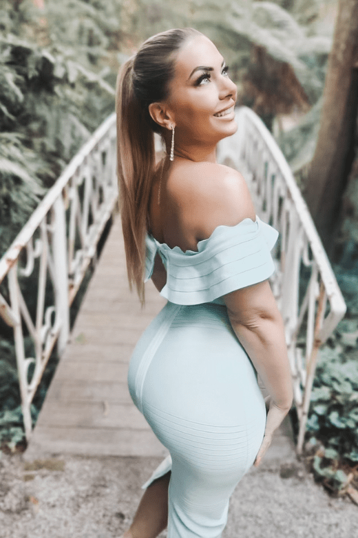 Woman wearing a figure flattering Billie Bandage Midi Dress - Classic Black Bodycon Collection