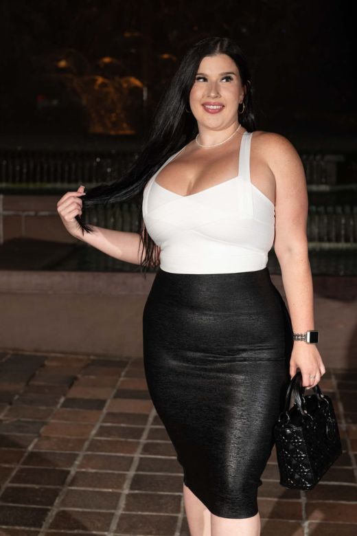 Woman wearing a figure flattering  High Waist Leather Pencil Skirt Midi Length - Metallic Black BODYCON COLLECTION