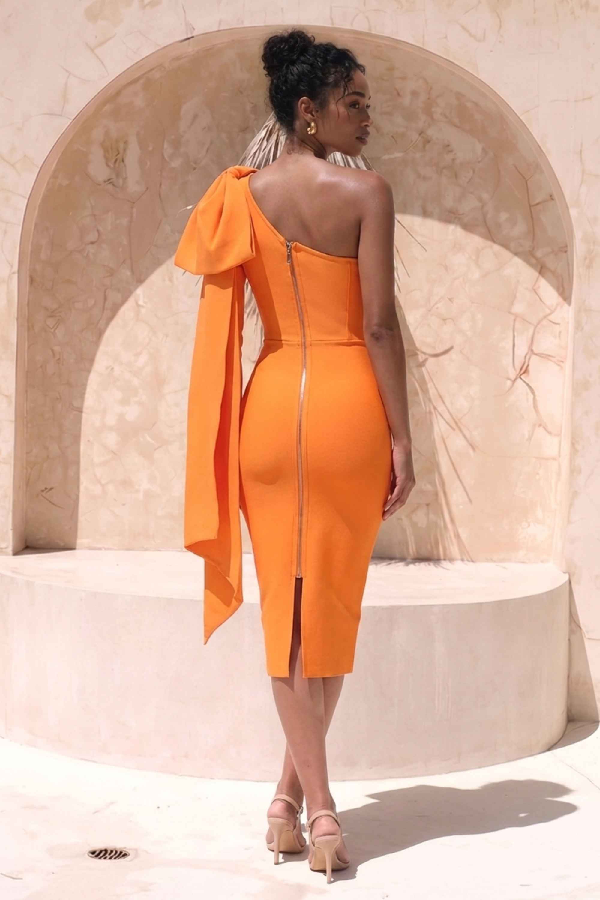 Woman wearing a figure flattering Lela Long Sleeve Bandage Midi Dress - Apricot Orange BODYCON COLLECTION