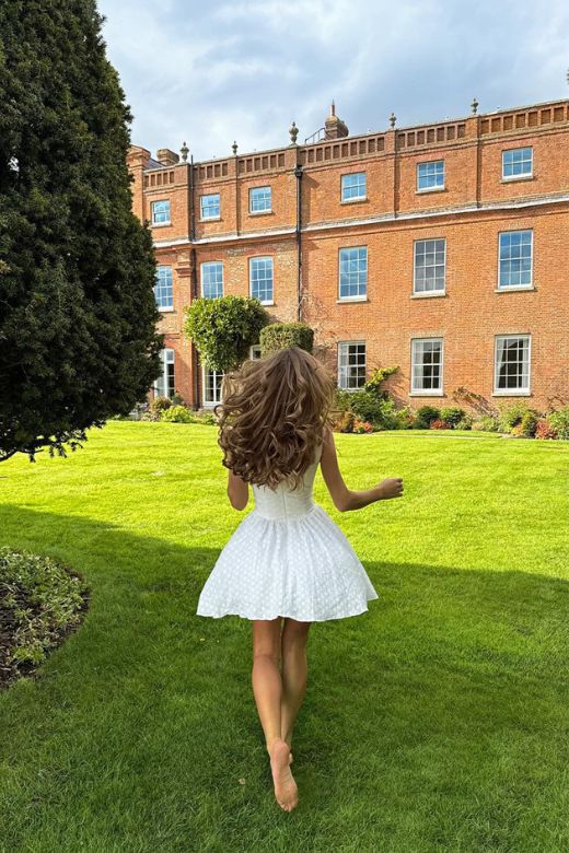 Woman wearing a figure flattering Mari Bodycon Mini Dress - Pearl White BODYCON COLLECTION