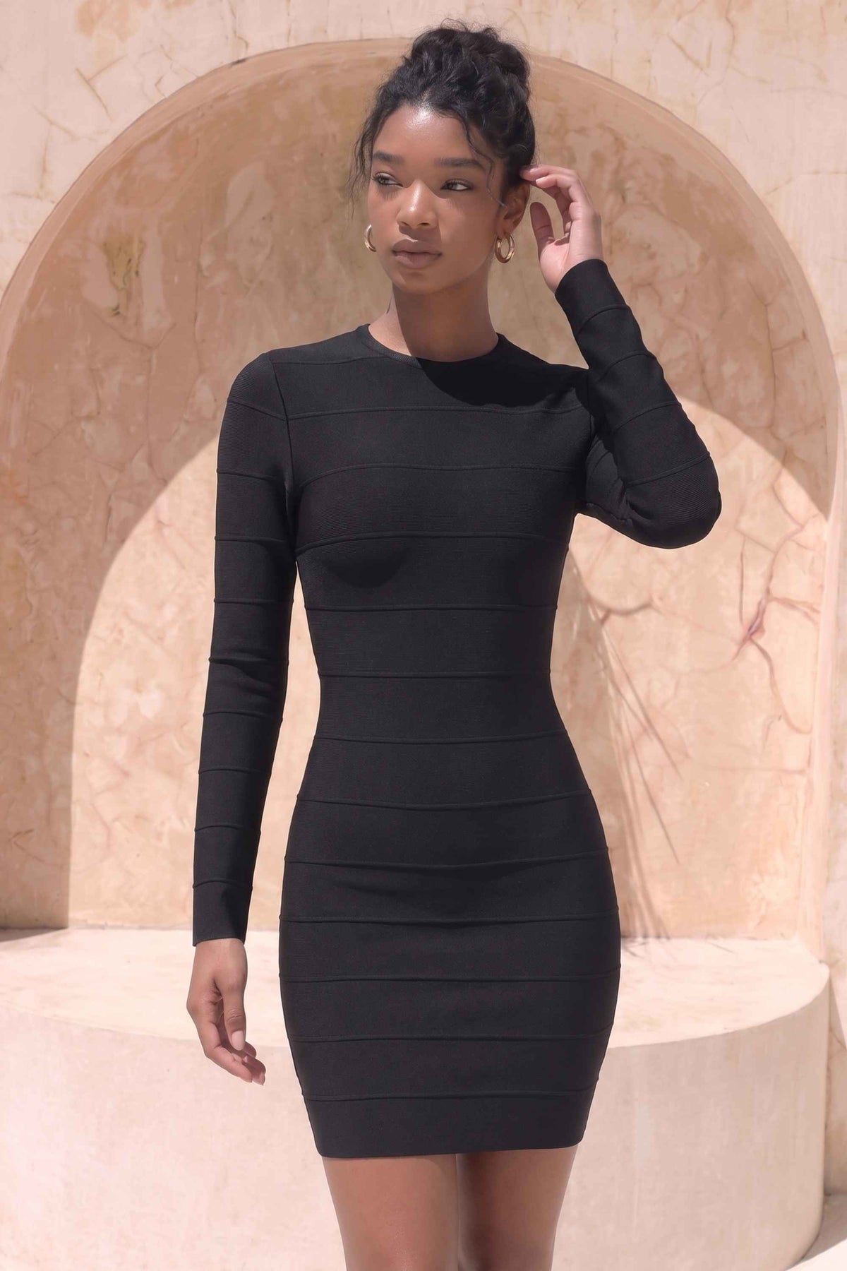Woman wearing a figure flattering Pamela Long Sleeve Bandage Mini Dress - Classic Black BODYCON COLLECTION