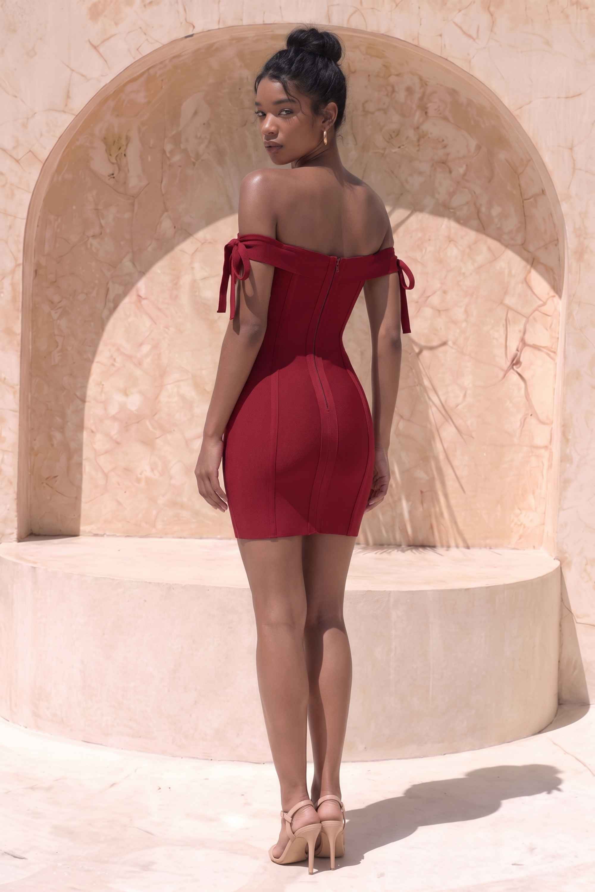 Woman wearing a figure flattering Penelope Bandage Mini Dress - Red Wine BODYCON COLLECTION