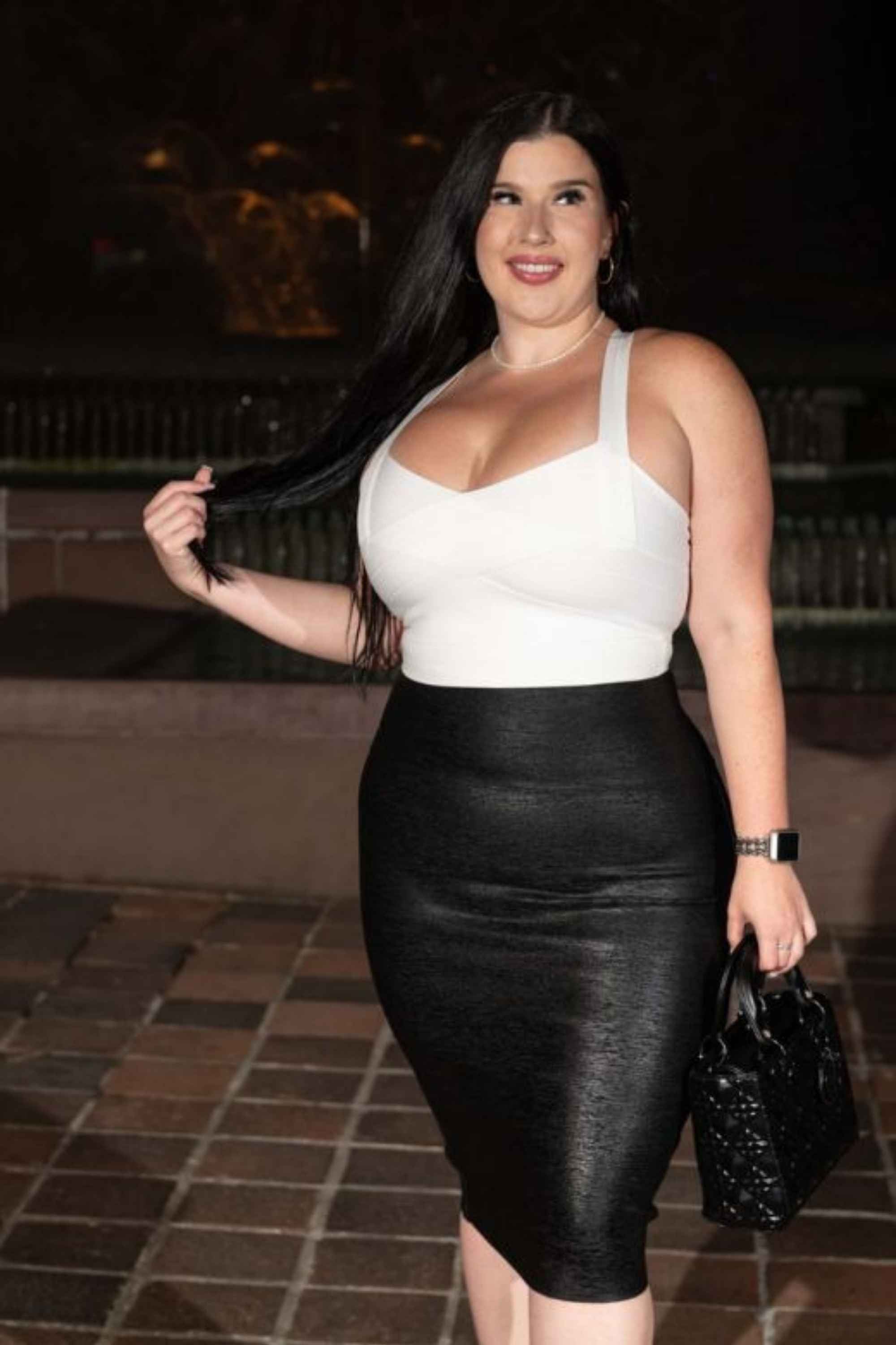 Woman wearing a figure flattering  High Waist Leather Pencil Skirt Midi Length - Metallic Black BODYCON COLLECTION
