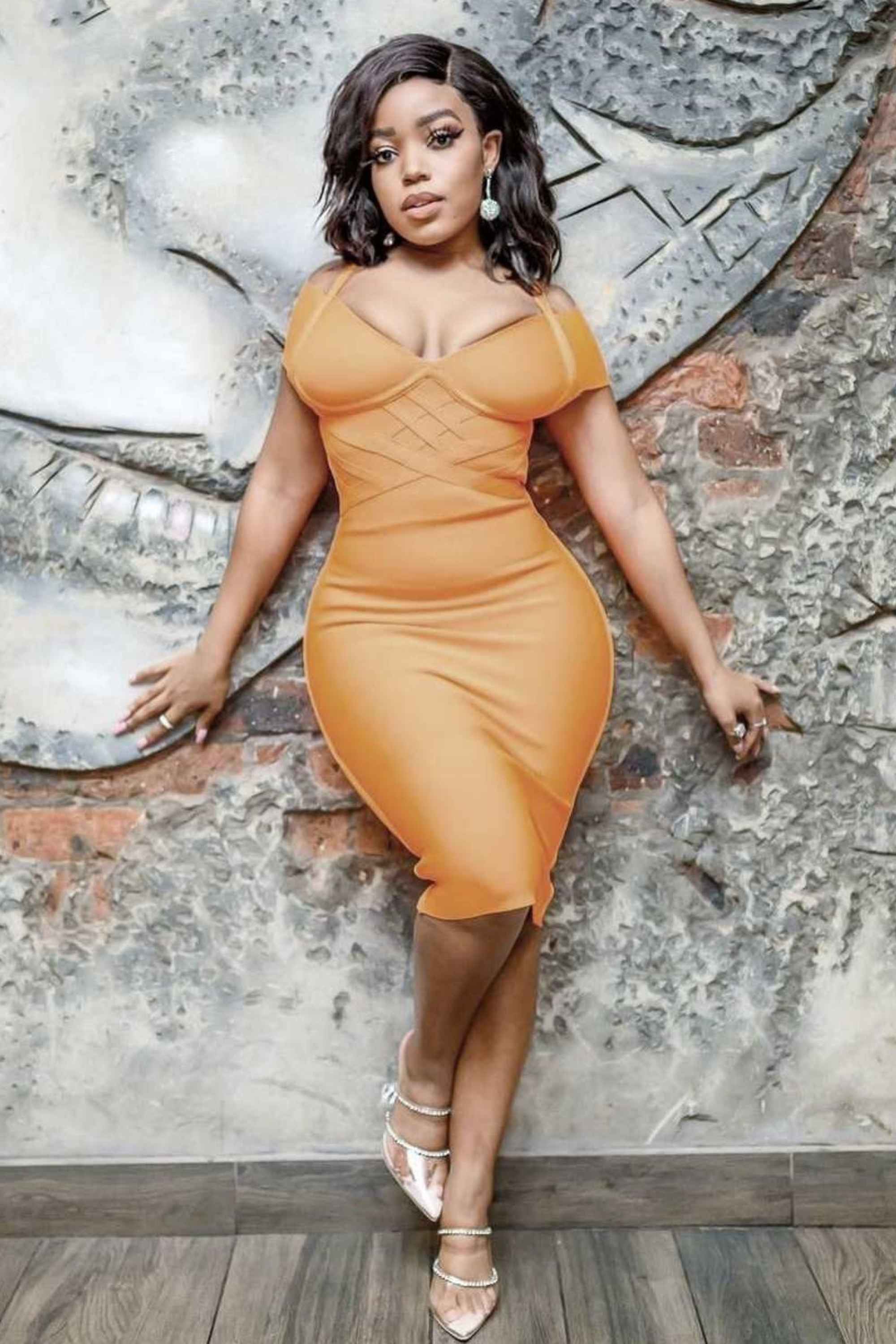 Woman wearing a figure flattering  Leo Bandage Dress - Apricot Orange Bodycon Collection
