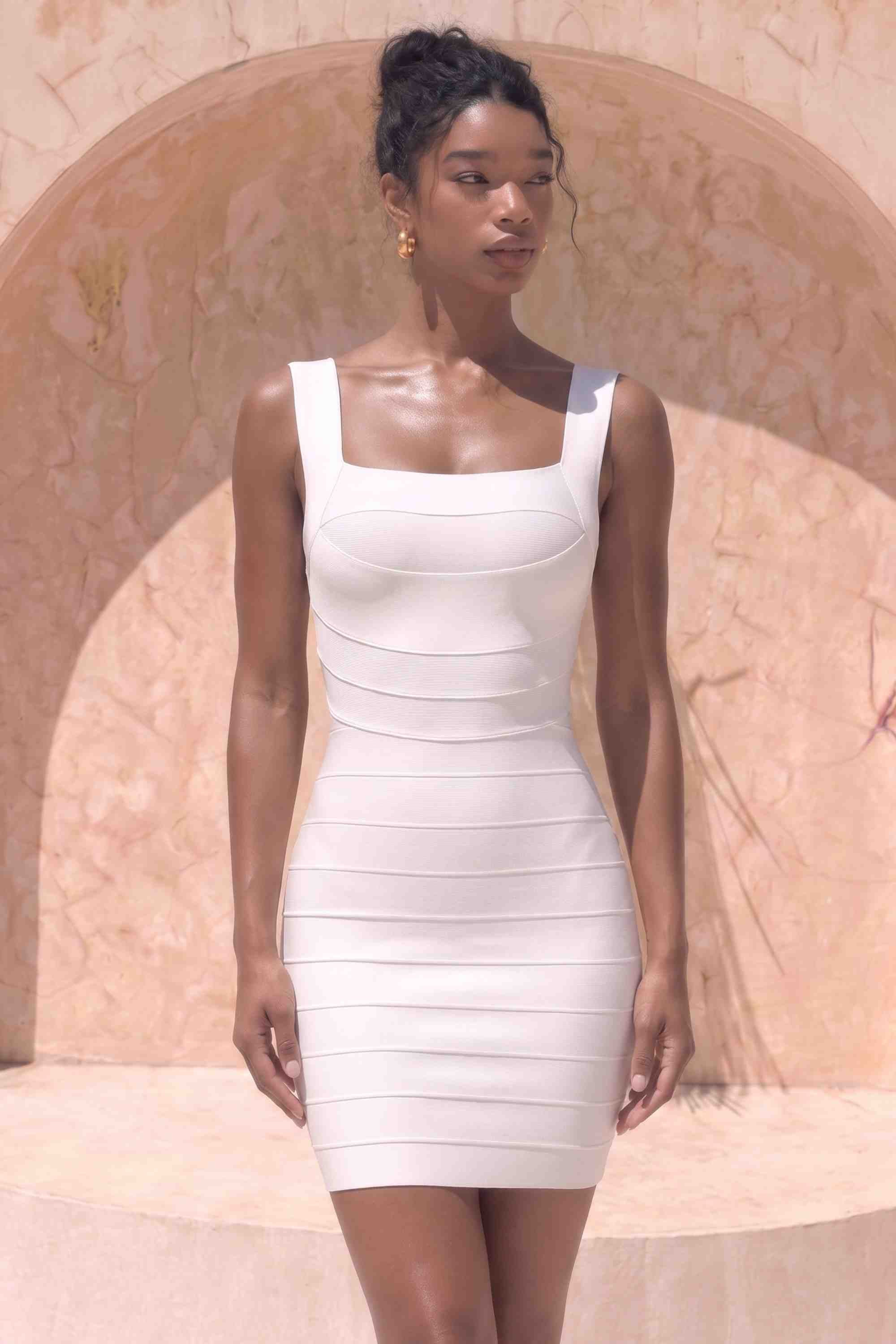 Woman wearing a figure flattering  Madelyn Bandage Mini Dress - White Pearl BODYCON COLLECTION Pty Ltd