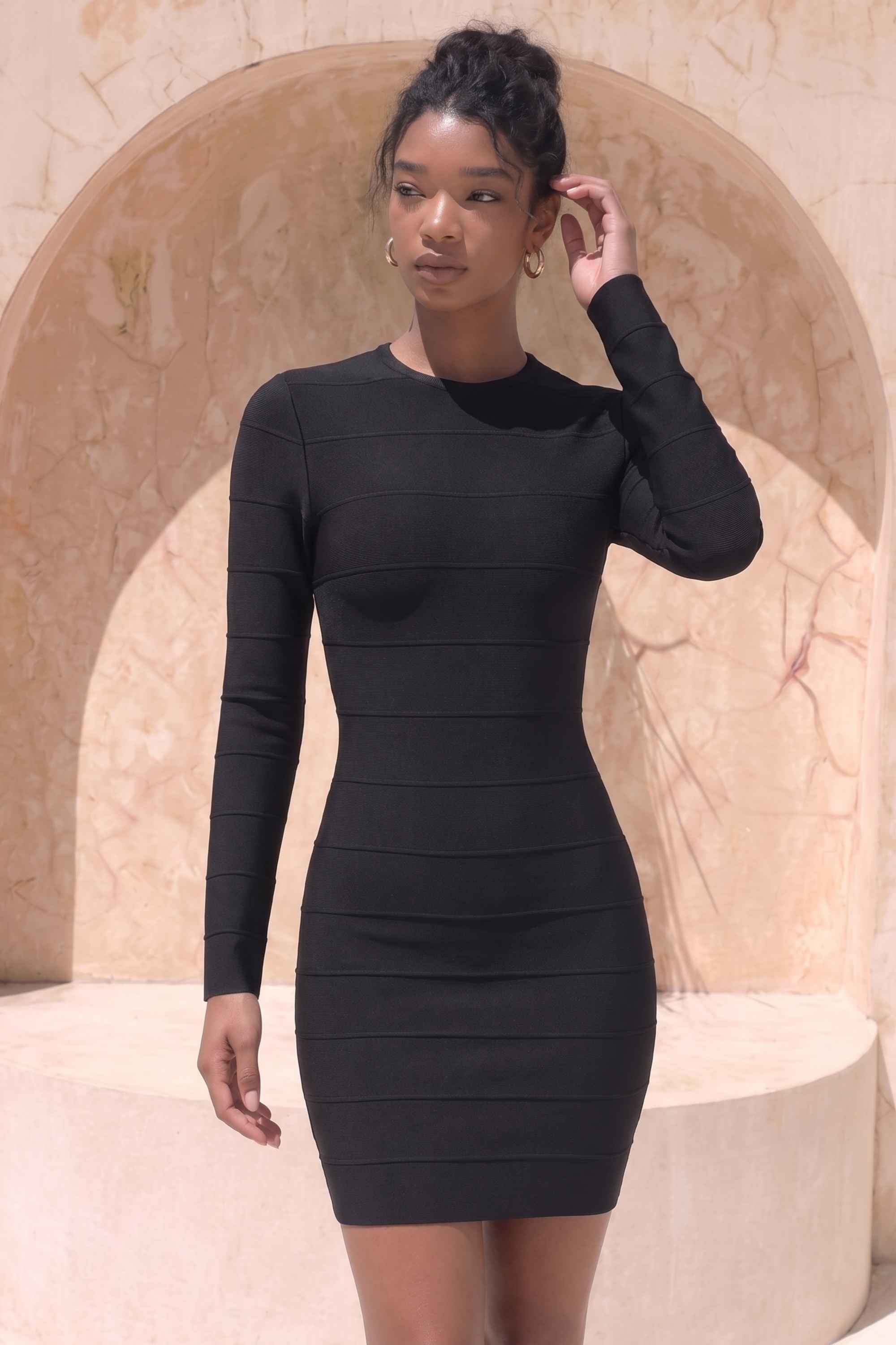 Woman wearing a figure flattering  Pamela Long Sleeve Bandage Mini Dress - Classic Black BODYCON COLLECTION