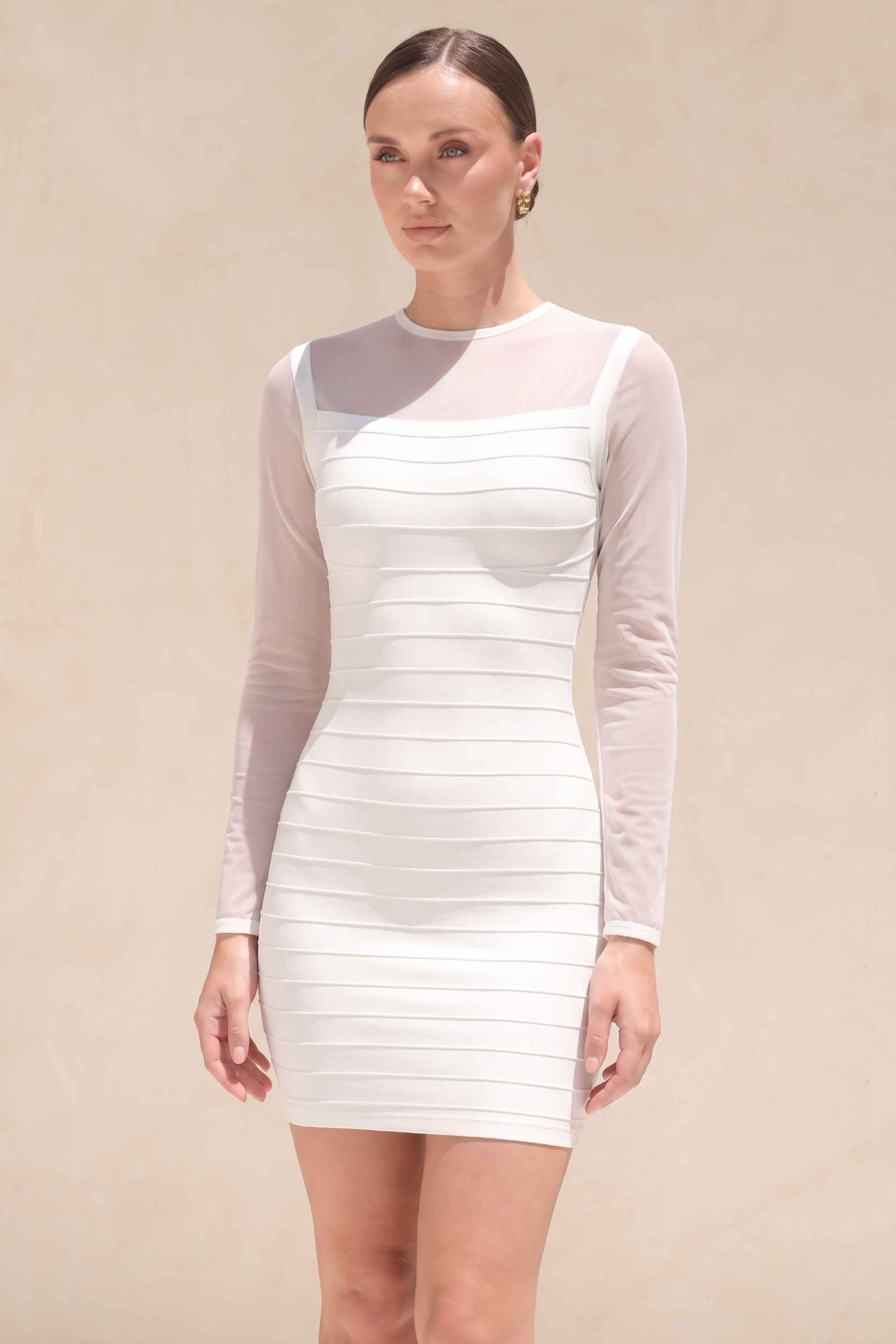 Woman wearing a figure flattering  Robin Long Sleeve Bandage Mini Dress - White Pearl BODYCON COLLECTION Pty Ltd